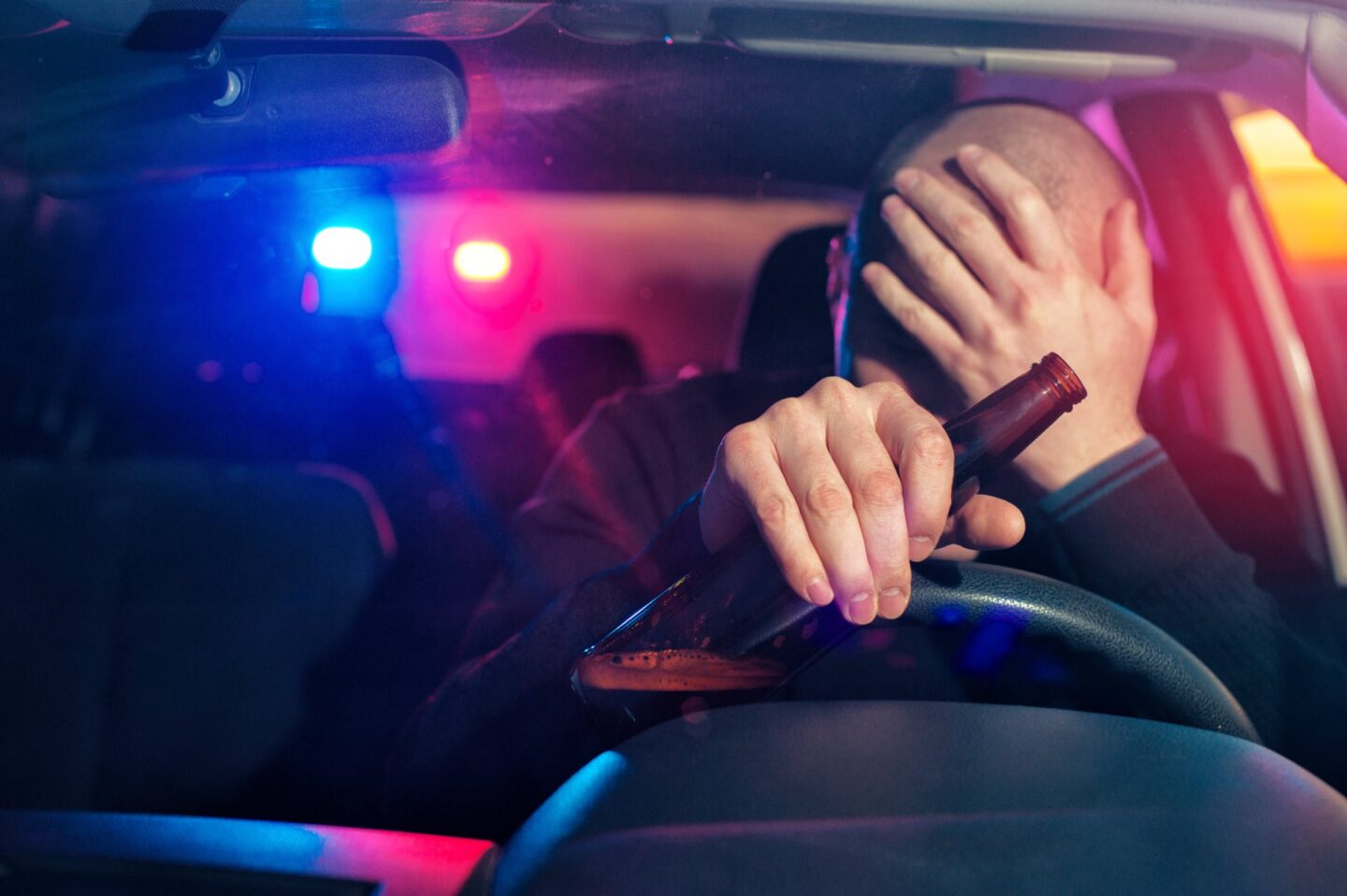driver is caught driving under alcohol influence. Man covering his face
